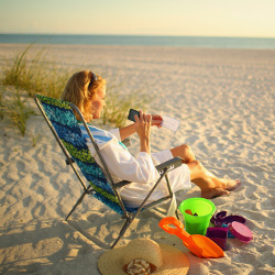 Photo of Women taking picture of check using mobile device on the beach